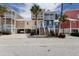 Inviting multi-story home with colorful exterior and a spacious front porch with white railings at 11780 Anglers Club Dr # 107, Placida, FL 33946