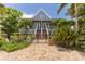 Charming two-story home with a fenced-in yard and stairs leading to a covered front porch at 11780 Anglers Club Dr # 107, Placida, FL 33946