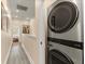 Well-lit hallway with stylish flooring leads to bedrooms and includes a modern washer and dryer at 11780 Anglers Club Dr # 107, Placida, FL 33946