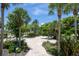 Walking path through the community surrounded by trees, bushes, and park benches at 11780 Anglers Club Dr # 107, Placida, FL 33946