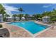 Spacious community pool surrounded by lush landscaping, cabanas, lounge chairs, and palm trees at 11780 Anglers Club Dr # 107, Placida, FL 33946