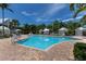 Beautiful community pool with brick pavers, lounge chairs, and cabanas under a sunny blue sky at 11780 Anglers Club Dr # 107, Placida, FL 33946