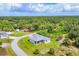 Aerial view of home surrounded by green space, lush trees and neighborhood at 123 Ferdon Cir, Port Charlotte, FL 33954