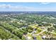 Aerial view of home set in a lush neighborhood surrounded by trees and winding roads at 123 Ferdon Cir, Port Charlotte, FL 33954