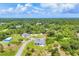 Aerial view of home in an area surrounded by lush greenery, trees and a winding road at 123 Ferdon Cir, Port Charlotte, FL 33954