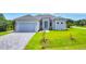 Charming single-story home featuring a paved driveway and lush green lawn at 123 Ferdon Cir, Port Charlotte, FL 33954