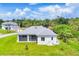 Aerial view of home with screened in back porch, lush lawn and blue skies at 123 Ferdon Cir, Port Charlotte, FL 33954