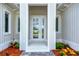Close up of the front door framed by columns and surrounded by vibrant landscaping at 123 Ferdon Cir, Port Charlotte, FL 33954