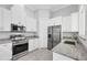 Bright kitchen featuring stainless steel appliances, granite countertops, and white cabinets with modern hardware at 123 Ferdon Cir, Port Charlotte, FL 33954