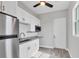 A minimalist kitchen featuring white cabinets, stainless steel appliances, and wood-look flooring at 123 Ferdon Cir, Port Charlotte, FL 33954