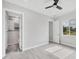 Main bedroom with attached bath featuring luxury tile flooring, ceiling fan and a window at 123 Ferdon Cir, Port Charlotte, FL 33954