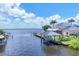 An aerial view reveals a waterfront property featuring a private dock, boat lift, and lush landscaping for premium living at 12438 Prather Ave, Port Charlotte, FL 33981
