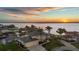 Beautiful waterfront estate home with a three-car garage, well-manicured lawn, and lush landscaping at sunset at 12438 Prather Ave, Port Charlotte, FL 33981