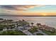 Waterfront estate property at sunset featuring private dock, boat house, lush landscaping, and circular driveway at 12438 Prather Ave, Port Charlotte, FL 33981