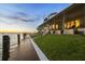 Large backyard with covered patio and long dock extending into the open water at sunset at 12438 Prather Ave, Port Charlotte, FL 33981