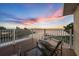Waterfront balcony with seating area, wooden floor, and beautiful views overlooking the canal and colorful sunset sky at 12438 Prather Ave, Port Charlotte, FL 33981