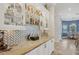 Wet bar area with decorative backsplash, stone counters, and views of the kitchen and dining areas at 12438 Prather Ave, Port Charlotte, FL 33981