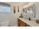 This charming bathroom has a wood vanity and large mirror at 12438 Prather Ave, Port Charlotte, FL 33981