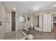 An elegant bathroom featuring a large walk-in shower with pebble flooring, a crystal chandelier, and contemporary design at 12438 Prather Ave, Port Charlotte, FL 33981
