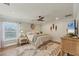 Comfortable bedroom with neutral walls, hardwood floors, ceiling fan, and a large window at 12438 Prather Ave, Port Charlotte, FL 33981