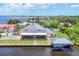 Desirable waterfront property featuring a private dock, boat house, outdoor living area, and landscaped grounds at 12438 Prather Ave, Port Charlotte, FL 33981