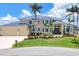 Two-story waterfront home features a metal roof, three-car garage, and beautiful landscaping at 12438 Prather Ave, Port Charlotte, FL 33981