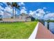 A spacious backyard features a manicured lawn and an expansive private dock for convenient boating and water activities at 12438 Prather Ave, Port Charlotte, FL 33981