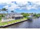 Beautiful waterfront estate home featuring a private dock, boat house, pool, and lush landscaping at 12438 Prather Ave, Port Charlotte, FL 33981