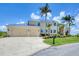 Two-story home with a metal roof, three-car garage, and meticulously maintained landscaping at 12438 Prather Ave, Port Charlotte, FL 33981