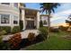 Close up front exterior of home with tropical flowers, well manicured lawn, and double door entry at 12438 Prather Ave, Port Charlotte, FL 33981