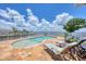 Sun loungers surround a glistening pool with views of the tranquil waters, ideal for luxurious outdoor relaxation at 12438 Prather Ave, Port Charlotte, FL 33981