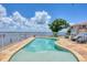 A sparkling pool with a tan-colored stone deck area invites residents to relax in luxury while enjoying water views at 12438 Prather Ave, Port Charlotte, FL 33981