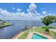 Aerial view of a pool area overlooking a tranquil river, lush landscaping, and backyard at 12438 Prather Ave, Port Charlotte, FL 33981