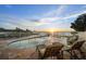 Backyard swimming pool with lounge chairs and peaceful water views at sunset at 12438 Prather Ave, Port Charlotte, FL 33981