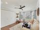 Sitting room features a comfortable couch, large windows, wood floors, and ceiling fan at 12438 Prather Ave, Port Charlotte, FL 33981