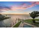 Waterfront view showcasing the dock, boat lift, and pool overlooking the open water at sunset at 12438 Prather Ave, Port Charlotte, FL 33981