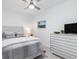 Bright bedroom with a ceiling fan, a painting and a modern dresser at 12550 Galapagos Ct # 104, Venice, FL 34293