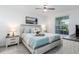 Bright bedroom with a ceiling fan, a painting and a well-lit window at 12550 Galapagos Ct # 104, Venice, FL 34293
