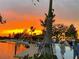Community park with walking path, small lake, and open-air venue beneath an orange sunset at 12550 Galapagos Ct # 104, Venice, FL 34293