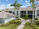 Exterior view of condos with screen enclosed lanais, tropical landscaping, and brick paver walkways at 12550 Galapagos Ct # 104, Venice, FL 34293