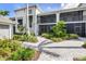 Exterior building view featuring brick pathway and tropical landscaping at 12550 Galapagos Ct # 104, Venice, FL 34293