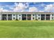 Back side of the building showing the screened in lanai and the green grassy area of the golf course at 12550 Galapagos Ct # 104, Venice, FL 34293
