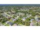 Wide aerial shot shows the neighborhood with mature trees surrounding a home with a large driveway at 1269 N Lavina St, North Port, FL 34286