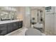 Modern bathroom with dual vanities, large mirror, and walk-in shower at 1269 N Lavina St, North Port, FL 34286