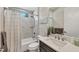 Bright bathroom featuring a shower over tub with marble tile surround and vanity with stone countertop at 1269 N Lavina St, North Port, FL 34286