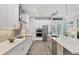 Bright kitchen with white cabinets, stainless steel appliances, and quartz countertops at 1269 N Lavina St, North Port, FL 34286