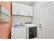 Efficient laundry room showcasing modern washer, dryer, and practical overhead cabinets for storage at 1269 N Lavina St, North Port, FL 34286