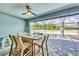 Cozy outdoor dining area with bar-style table and chairs offering a view of the screened-in pool at 1269 N Lavina St, North Port, FL 34286
