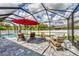 Relaxing outdoor patio offers comfortable seating and beautiful views of the screened-in pool and lush backyard at 1269 N Lavina St, North Port, FL 34286