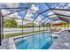 Sparkling screened-in pool with inviting lounge area, landscaping, and serene backyard views at 1269 N Lavina St, North Port, FL 34286